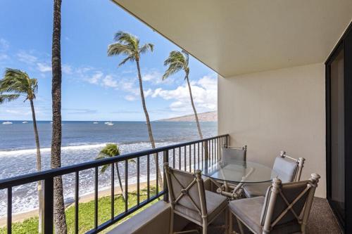 a balcony with a table and chairs and the ocean at SUGAR BEACH RESORT, #421 condo in Kihei