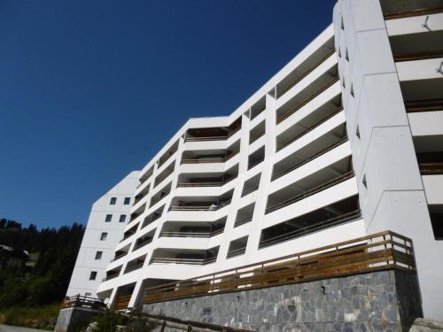 a tall white apartment building with a blue sky at Résidence Arche - Studio confortable · Centre station · Terrasse MAE-5084 in Magland