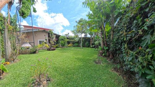 un cortile con prato verde e alberi e una casa di La Casa de Sonya a Concepción de Ataco