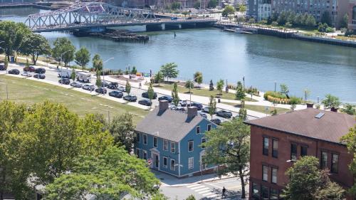 a blue house next to a river with a bridge at The Hill in Providence