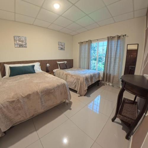 a bedroom with two beds and a desk in it at La Casa de Sonya in Concepción de Ataco
