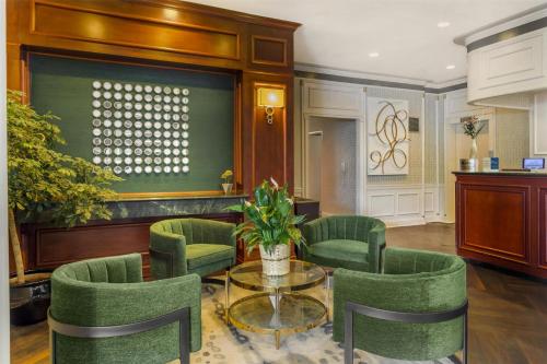 a living room with green chairs and a glass table at Best Western Queens Gold Coast in Queens