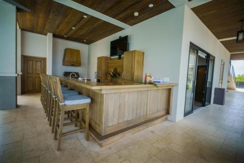 a kitchen with a counter with chairs and a bar at NEW 3 Story Waterfront 4Bedroom Villa with Amazing Sunset Mountain Views in Maya Beach
