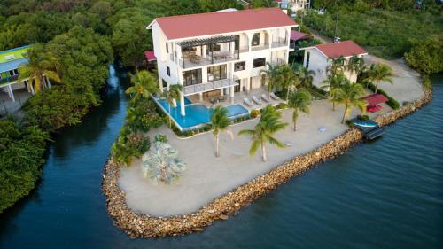 an aerial view of a house on an island in the water at NEW 3 Story Waterfront 4Bedroom Villa with Amazing Sunset Mountain Views in Maya Beach