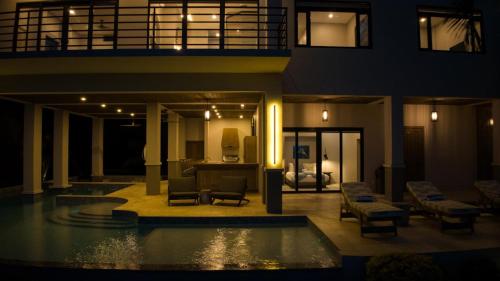 a house with a swimming pool at night at NEW 3 Story Waterfront 4Bedroom Villa with Amazing Sunset Mountain Views in Maya Beach