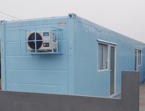 a blue building with a fan in the window at Estudio Vila dos Pescadores in São Francisco do Sul