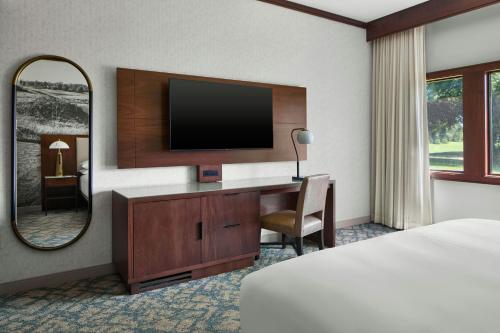 a hotel room with a bed and a desk with a television at Montgomery Marriott Prattville Hotel & Conf Ctr at Capitol Hill in Prattville