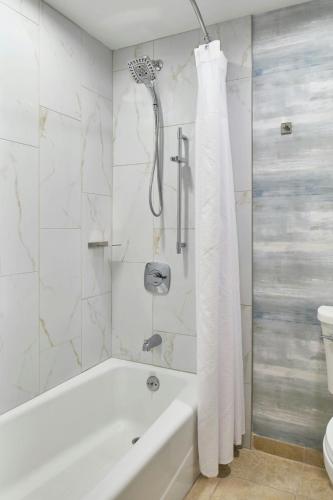 a white bathroom with a tub and a toilet at Montgomery Marriott Prattville Hotel & Conf Ctr at Capitol Hill in Prattville
