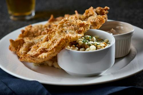 a plate of food with chicken and a bowl of dip at Montgomery Marriott Prattville Hotel & Conf Ctr at Capitol Hill in Prattville