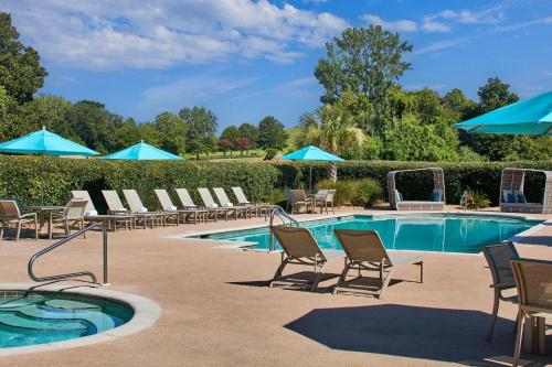 a swimming pool with lounge chairs and umbrellas at Montgomery Marriott Prattville Hotel & Conf Ctr at Capitol Hill in Prattville