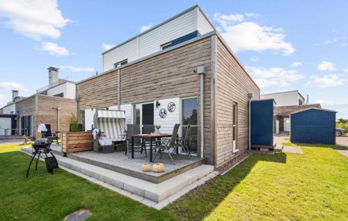 ein Haus mit einer Terrasse mit einem Tisch in einem Hof in der Unterkunft Thor in Tossenserdeich