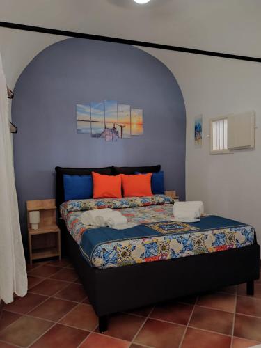 a bedroom with a bed with a blue wall at Casa Frufa in Terrasini