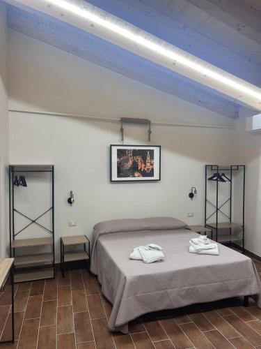 a bedroom with a bed and two shelves in it at Brèbrè in San Giovanni Gemini