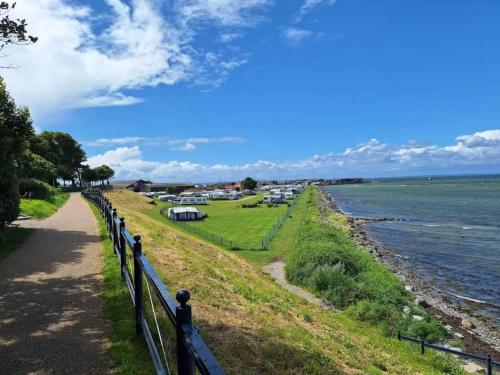 a walkway next to the ocean with a fence at 5 person holiday park in Bogense in Bogense