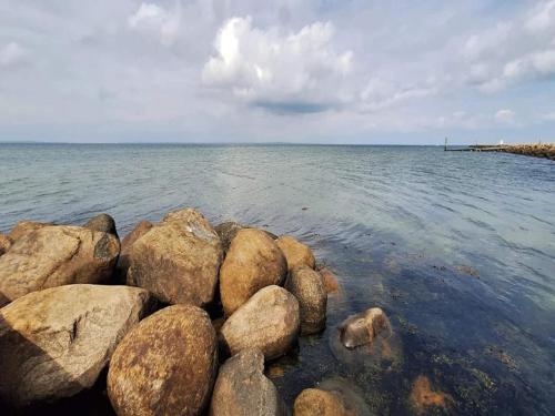 a group of rocks in the water on a beach at 5 person holiday park in Bogense in Bogense