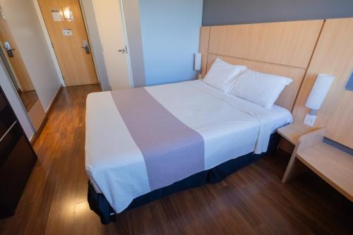 a large white bed in a small room at ibis Contagem Ceasa in Contagem