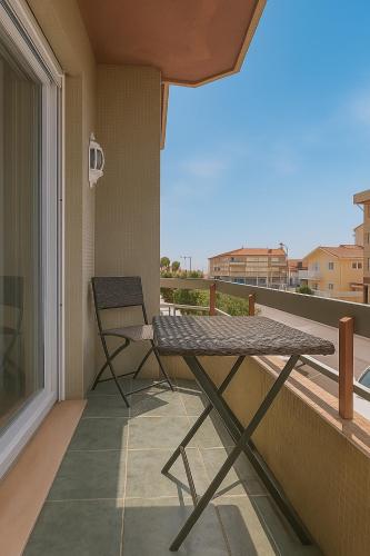 a table and a chair on a balcony at Paraíso no Furadouro, T2 a apenas alguns passos da praia in Ovar