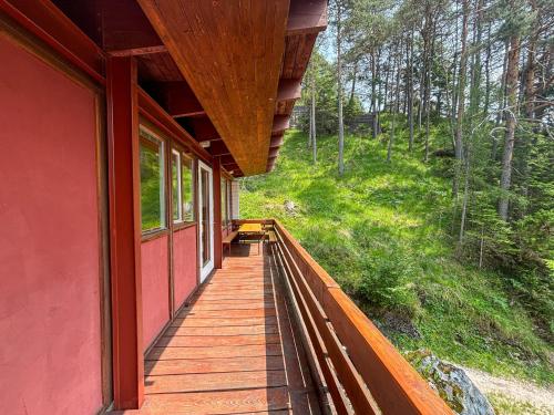 a porch of a red house with a wooden walkway at Chalet Auralpina near Cortina Olympics Games 2026 in Borca di Cadore