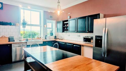 a kitchen with a table and a refrigerator at Victorian Town House - Sleeps 6 in Tywyn