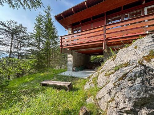 a house on top of a rock with a bench at Chalet Auralpina near Cortina Olympics Games 2026 in Borca di Cadore