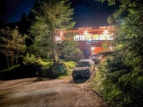 a car parked in front of a house at night at Chalet Auralpina near Cortina Olympics Games 2026 in Borca di Cadore