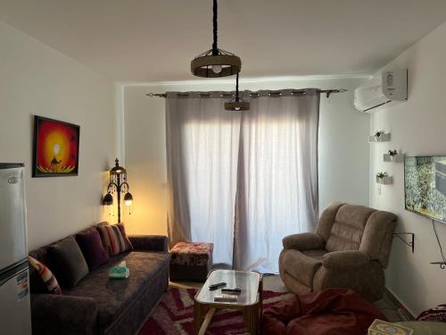 a living room with a couch and a chair at Mountain View Resort Chalet in Ras El Hekma in Ras Elhekma