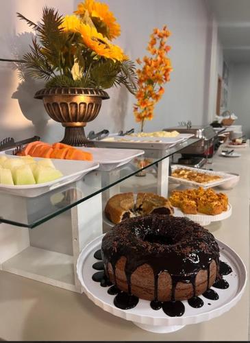 a display case with a chocolate cake and other desserts at Hotel Du Rastro in Louro Müller