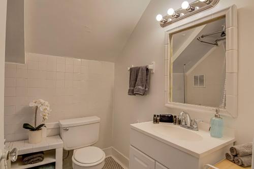 a bathroom with a toilet and a sink and a mirror at Entire home in Greensboro 1 Mile From Downtown and Amazing Restaurants in Greensboro