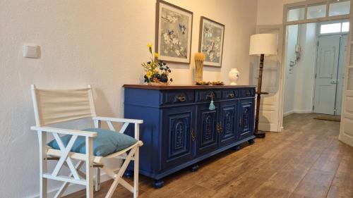 a blue dresser in a room with two chairs at Cantinho de Terena - Cheiros Da Terra in Terena