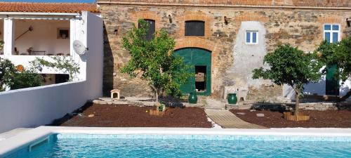 a house with a swimming pool in front of a building at Cantinho de Terena - Cheiros Da Terra in Terena