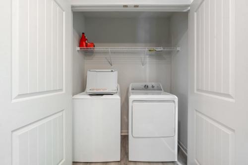 a small kitchen with two washes and a stove at Elegant 3BR Retreat King Bed Near Cary & NC State in Raleigh