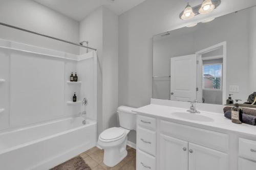 a white bathroom with a toilet and a sink at Luxe King 4 BR Townhouse Mins to Dwtn Durham in Durham