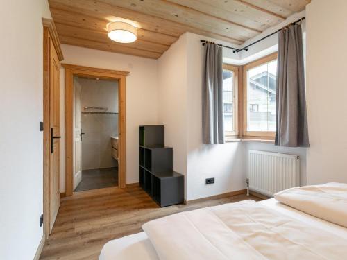 a bedroom with a bed and a window and a bathroom at Appartement Dörler in Kirchberg in Tirol