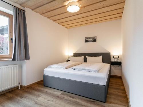 a bedroom with a bed with a wooden ceiling at Appartement Dörler in Kirchberg in Tirol