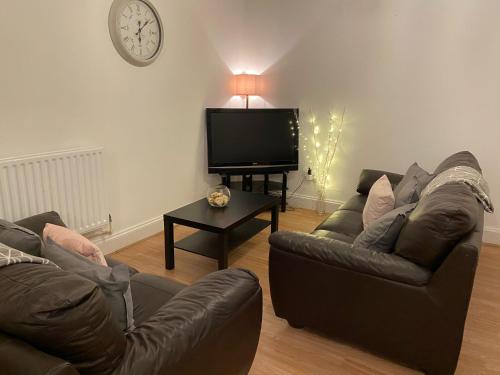 a living room with two couches and a flat screen tv at 2 Bed Deluxe Apartment, City Centre, Allocated Parking, Fast WiFi by Opulent Stays in Derby