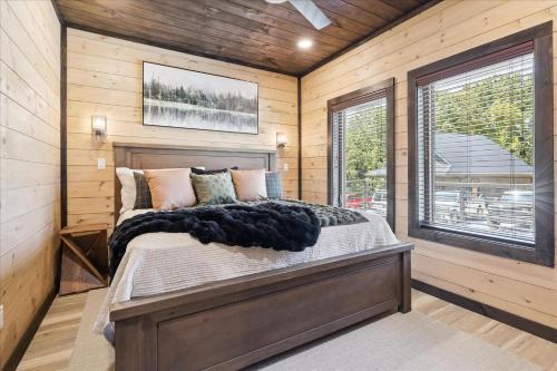 une chambre avec un lit dans une pièce aux murs en bois dans l'établissement New Roof Top Patio Home Wpool, Hot Tub & Game Rm, à Pigeon Forge
