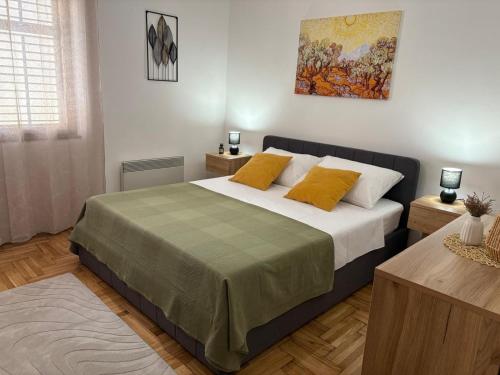 a bedroom with a large bed with yellow pillows at Apartments with parking space Kraj, Pasman - 8372 in Tkon