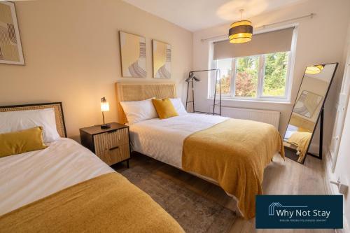 a bedroom with two beds and a window at Stylish 5 bed home in Beeston in Nottingham