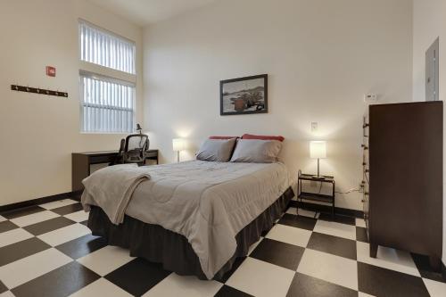 een slaapkamer met een bed en een geruite vloer bij Brunswick Studio 102 in Kingman