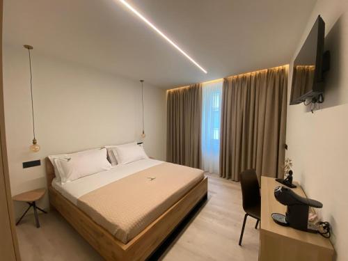 トレントにあるB&B Tower Suite Trentoのベッドと机とテレビのある寝室