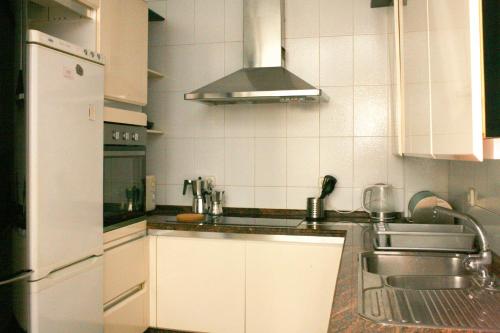 a kitchen with white cabinets and a sink at Caleta Club - 4 BDR Rooftop Villa in Cádiz
