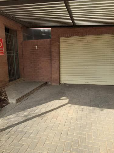 a garage with two garage doors in a brick building at Gracious Beauty in Bloemfontein