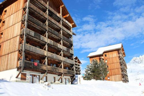 a large building in the snow next to a building at Les Chalets De Superd Bleuet - 2 Pièces pour 4 Personnes MAE-8884 in Le Dévoluy