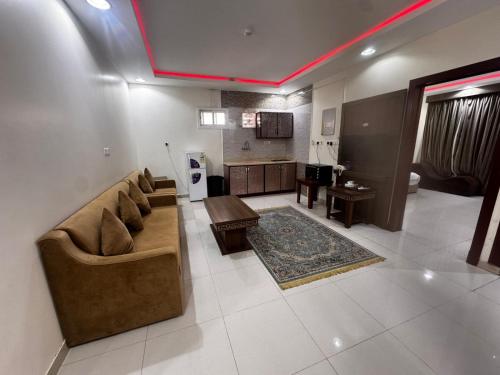 una sala de estar con un sofá y una mesa en شقق ظل النخيل للشقق المخدومة, en Hotat bani tamim
