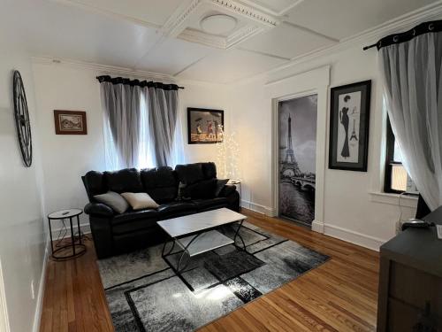 a living room with a black couch and a table at Little France Unit 2 in Allentown