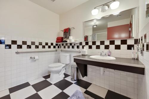 een badkamer met een toilet, een wastafel en een spiegel bij Brunswick Studio 102 in Kingman
