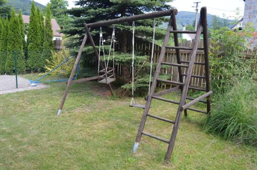 an old swing set with a ladder in a yard at Apartmany Agatha in Loučná nad Desnou