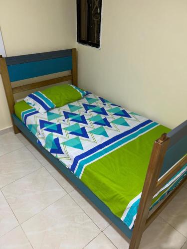 a bed with a green and blue comforter at Hermoso apto piso 2 barrio san jose in Barranquilla