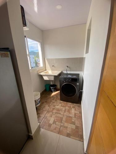 a small kitchen with a washer and dryer in a room at Nido de Paz Amplio, Moderno y Acogedor in Bonao