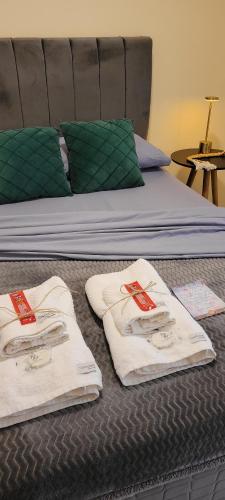 a bed with two white towels on top of it at Casa Centro de Guabiruba in Guabiruba